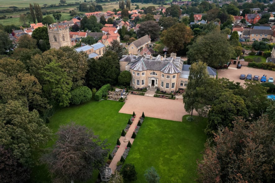 a drone image has been taken overhead of Washingborough Hall, with the grounds in the front, and the church and village behind the hotel